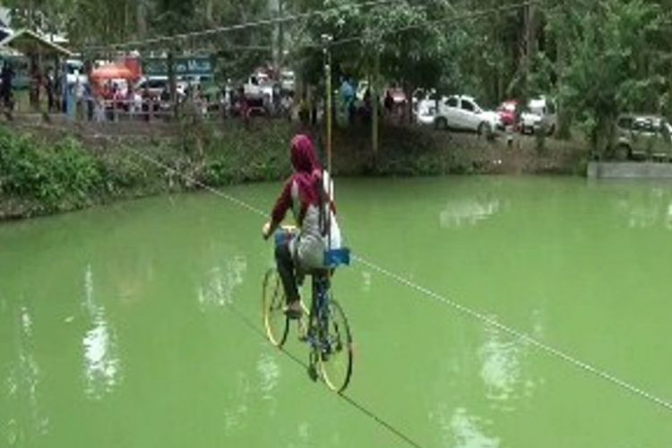 Ngabuburit sambil bersepeda di atas bentangan tali sambil melintasi telaga menjadi salah satu cara baru warga Polewali Mandar, Sulawesi Barat, Kamis (1/6/2017), menanti waktu berbuka puasa atau ngabuburit.
