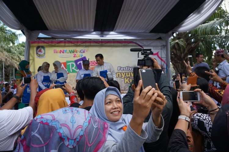 Seorang ibu sedang selfie berlatarbelakang Chef Juna yang sedanh memasak bersama Bupati Banyuwangi Abdullah Azwar Anas di Festival Banyuwangi Kuliner Rabu (12/4/2017)