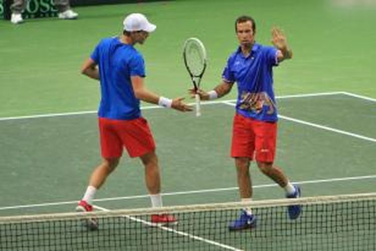 Petenis Ceko, Tomas Berdych (kiri) melakukan tos dengan Radek Stepanek setelah meraih poin atas Carlos Berlocq/Horacio Zeballos dari Argentina, pada laga semifinal Davis Cup, Sabtu (14/9/2013).