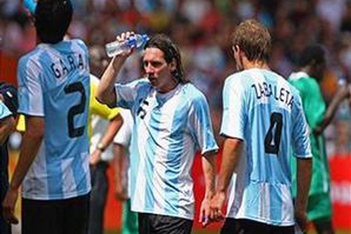 Lionel Messi (tengah) dan pemain lain pada final sepak bola putra Olimpiade Beijing beristirahat sejenak untuk minum dan mendinginkan badan di sela-sela pertandingan. Pertandingan pada Sabtu (23/8) siang itu berlangsung di bawah suhu 42 derajat Celsius.