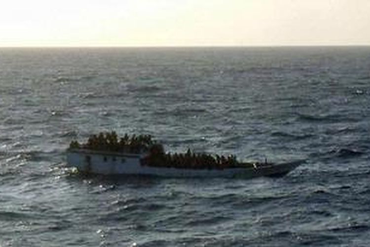 Foto yang diambil kru kapal MV Bison Express, dan dirilis Otoritas Keselamatan Maritim Australia (AMSA),  menunjukkan kapal kecil disesaki lebih dari 100 pencari suaka ke Australia. Kapal itu terbalik dan tenggelam di 107 mil laut utara Pulau Christmas, Australia, Rabu (27/6/2012). MV Bison Express dan dua kapal dagang lain serta dua kapal AL Australia berhasil menyelamatkan 123 penumpang.  