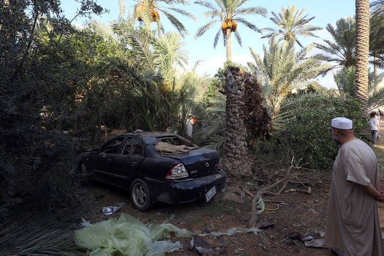 Warga Libya melihat lokasi tempat jatuhnya roket setelah bentrokan antara kelompok misili, di ibu kota Tripoli, Kamis (30/8/2018).