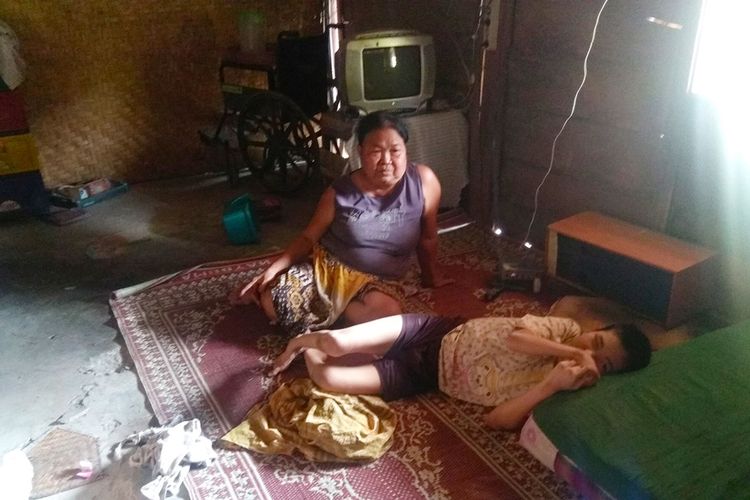 Suyati bersama anaknya Rini (45) yang menderita lumpuh. Selama 45 tahun kegiatan anaknya hanya berbaring di kamar dan menonton televisi, Rabu (16/10/2019).