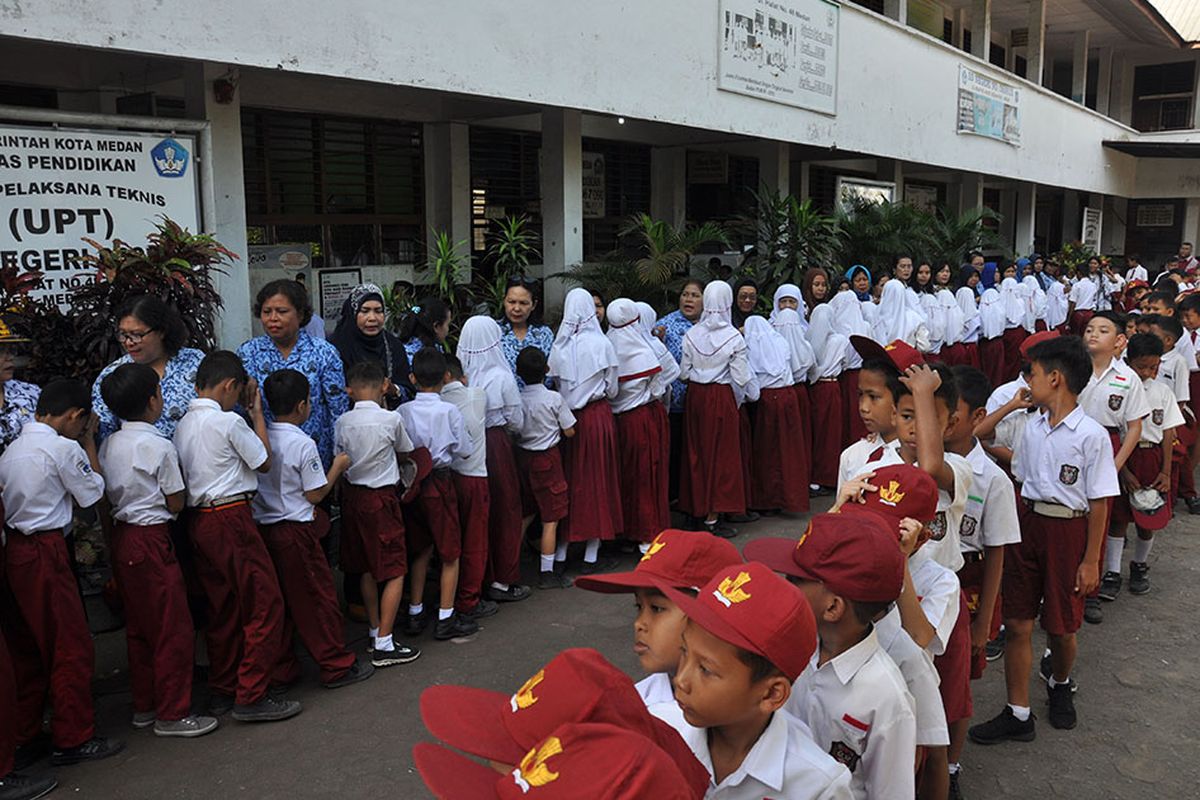 Sejumlah siswa menyalami guru mereka seusai mengikuti upacara di Sekolah Dasar Negeri 060813 Medan, Sumatera Utara, Senin (25/11/2019). Menyalami guru oleh para siswa tersebut dalam rangka memperingati Hari Guru yang serentak dilaksanakan di seluruh Indonesia.