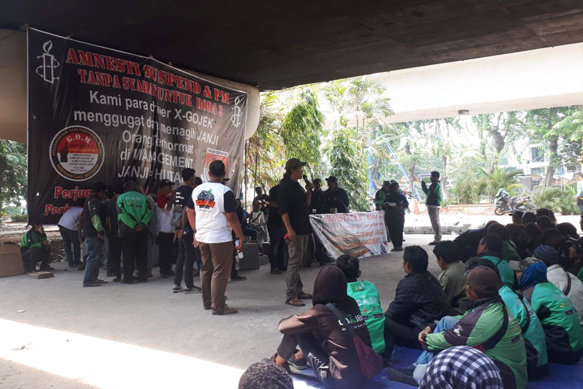 Sekitar 500 pengemudi Go-Jek berkumpul di kolong Flyover Pancoran, Jakarta Selatan, Minggu (21/10/2018) untuk menyatukan suara terkait tuntutan mereka kepada Go-Jek Indonesia.   Mereka menuntut Go-Jek Indonesia untuk mencabut aturan suspend atau pemutusan kerja yang dilakukan secara sepihak pada beberapa pengemudi.