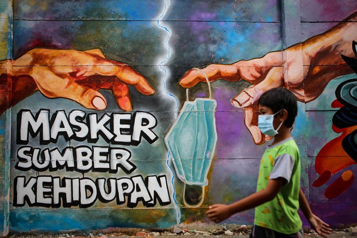 Seorang bocah melintas di depan mural tentang penggunaan masker di Kota Tangerang, Banten, Minggu (21/12/2020). Mural tersebut dibuat sebagai edukasi kepada masyarakat untuk selalu menggunakan masker guna mencegah penyebaran COVID-19. ANTARA FOTO/Fauzan/aww.