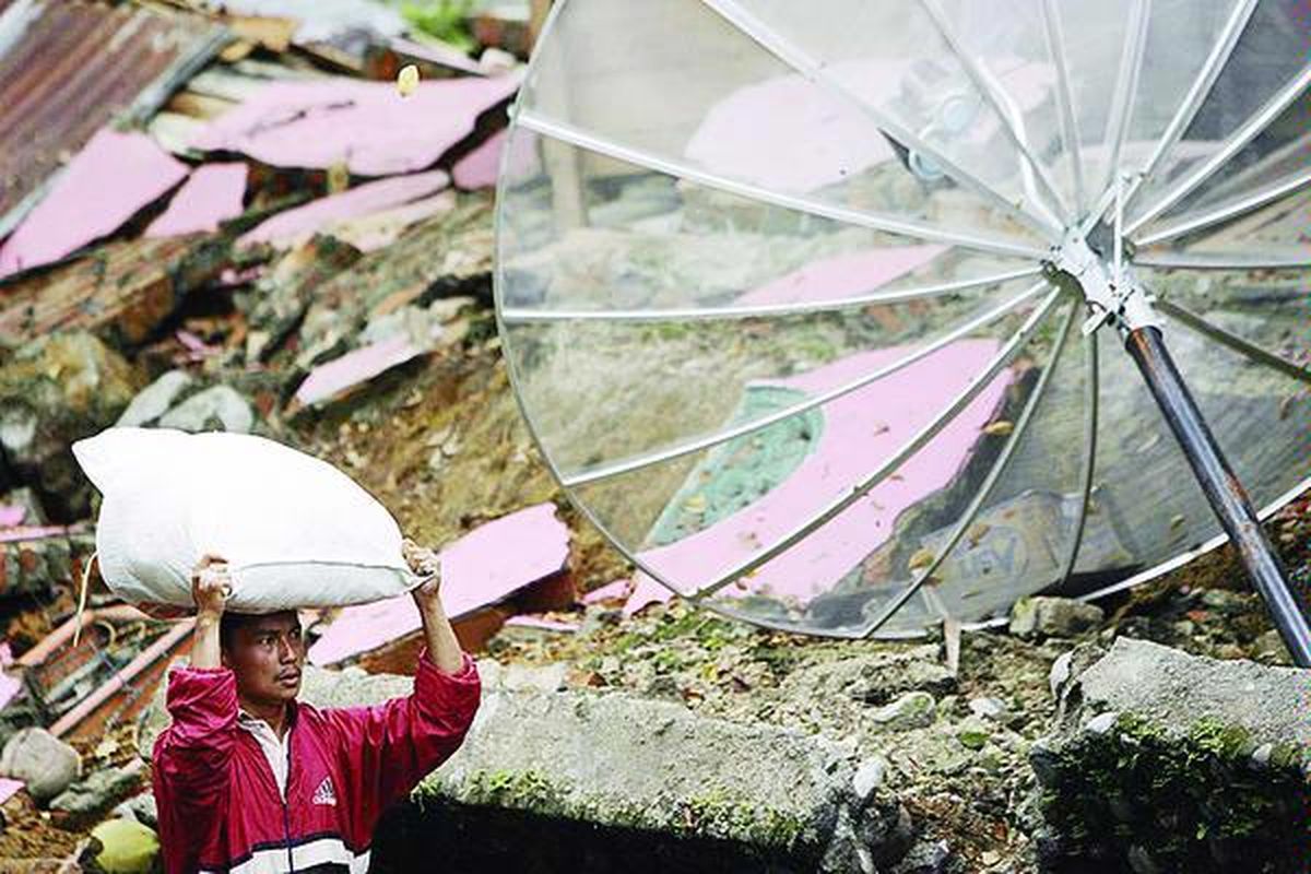 Warga membawa makanan untuk korban gempa bumi di Desa Gunung, Kecamatan V Koto Timur, Kabupaten Padang Pariaman, Sumatera Barat, Senin (5/10). Jalan yang terputus membuat jalur pendistribusian makanan dilakukan dengan jalan kaki dan helikopter.