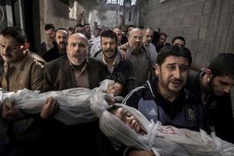 Warga Gaza membawa jenazah Suhaib Hijazi (2 tahun) dan Muhammad (3 tahun), yang tewas di rumah mereka yang hancur dalam serangan rudal Israel, 20 November 2012. Ayah mereka Fouad juga tewas.