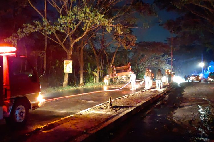 Petugas Damkar Kota Salatiga menyemprot material yang memenuhi jalan karena kecelakaan empat truk di JLS.