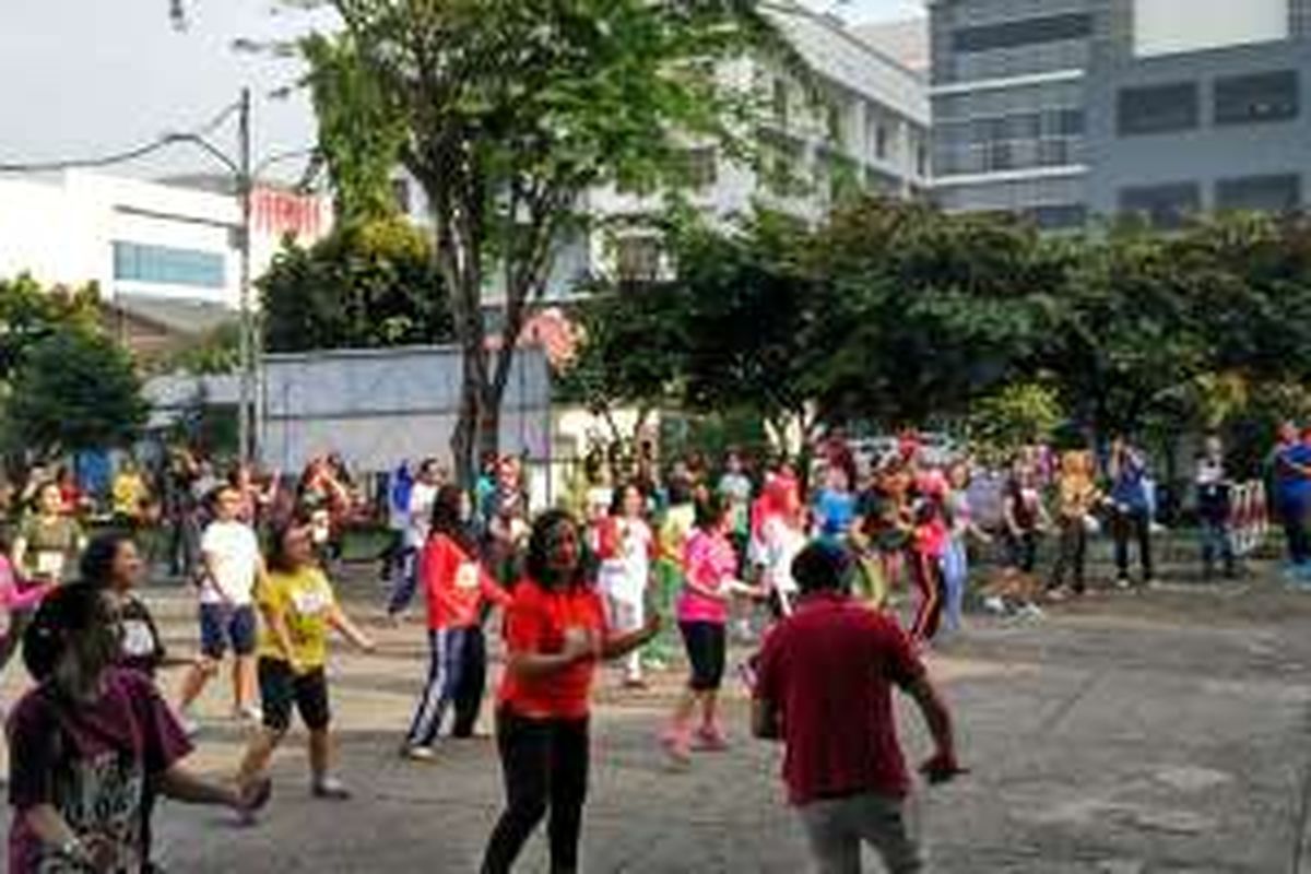 Karyawan Kompas Gramedia mengikuti senam aerobik di lapangan parkir Gedung Kompas Gramedia Palmerah Barat, Jakarta, Jumat (9/9/2016) waktu setempat.