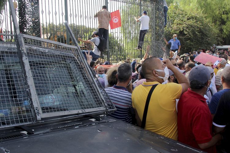 Demonstran menyerbu pintu masuk gedung parlemen di Tunis, ibu kota Tunisia, Senin (26/7/2021). Tentara berjaga mengelilingi gedung tersebut dan melarang ketua DPR masuk, setelah Presiden Kais Saied membekukan parlemen dan memecat perdana menteri.