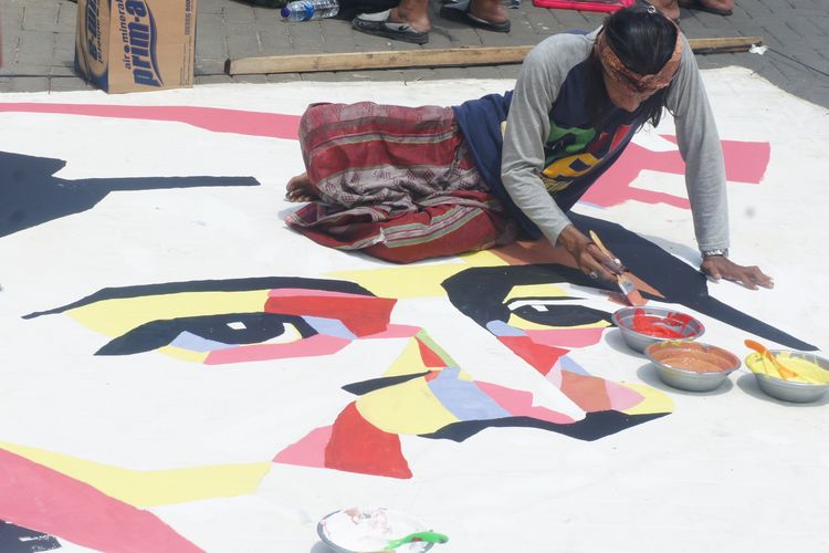 Aboy Atap Langit tengah melukis Kartini di atad kanvas berukuran 5x7 meter, di pelataran Festive Walk, Galuh Mas, Karawang, Minggu (21/4/2019).