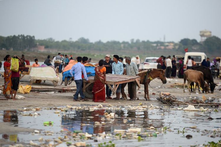 Para pedagang bersiap untuk memindahkan tempat penampungan sementara mereka dari tepi Sungai Gangga saat permukaan air sungai meningkat karena hujan deras, di Allahabad pada tanggal 6 Juli 2017.