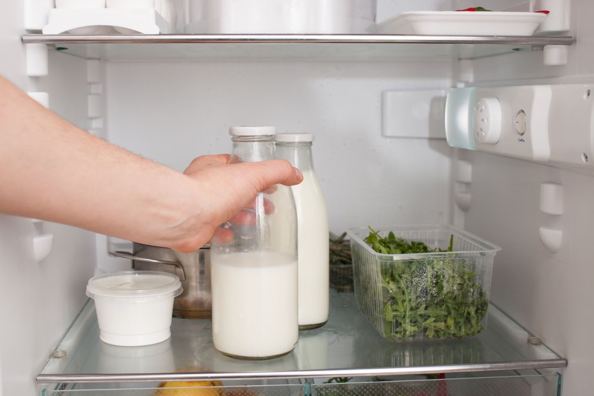 Ilustrasi susu sapi segar dalam botol disimpan di kulkas. 
