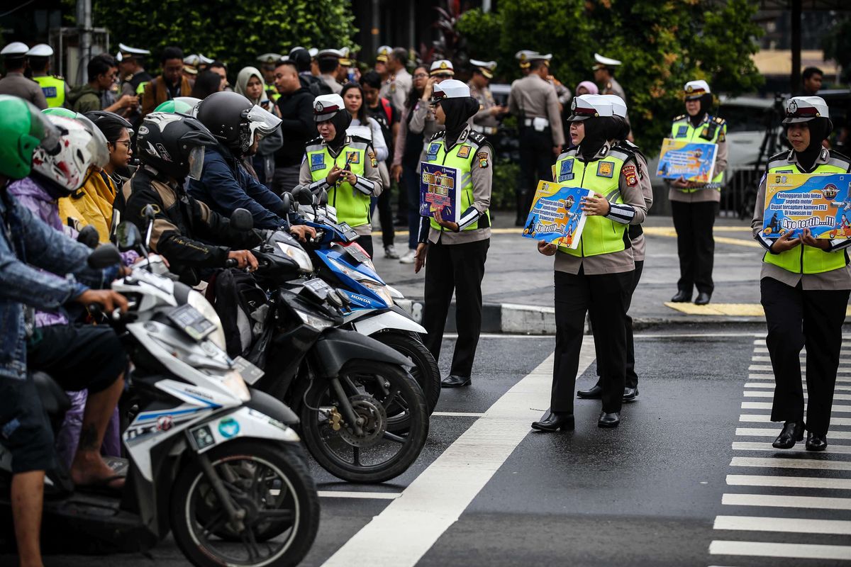 Petugas kepolisian dari direktorat lalu lintas (Ditlantas) Polda Metro Jaya menyosialisasikan penerapan sistem tilang elektronik atau electronic traffic law enforcement (ETLE) untuk kendaraan roda dua atau motor di Simpang Sarinah, Thamrin, Jakarta Pusat, Senin (3/2/2020). Untuk saat ini sistem ETLE untuk pengendara sepeda motor fokus pada penindakan tiga pelanggaran, yakni penggunaan helm, menerobos traffic light, dan melanggar marka jalan. Penerapan aturan tersebut telah resmi diberlakukan mulai Sabtu (1/2/2020).