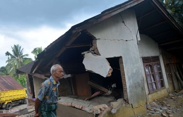 Warga melintas di depan rumah yang rusak akibat gempa di Jorong Pinagar, Nagari Aua Kuning, Kabupaten Pasaman Barat, Sumatera Barat, Jumat (25/2/2022).  Badan Nasional Penanggulangan Bencana (BNPB) menyatakan gempa berkekuatan magnitudo 6,2 di Pasaman Barat dan sekitarnya itu mengakibatkan tujuh warga meninggal dunia.