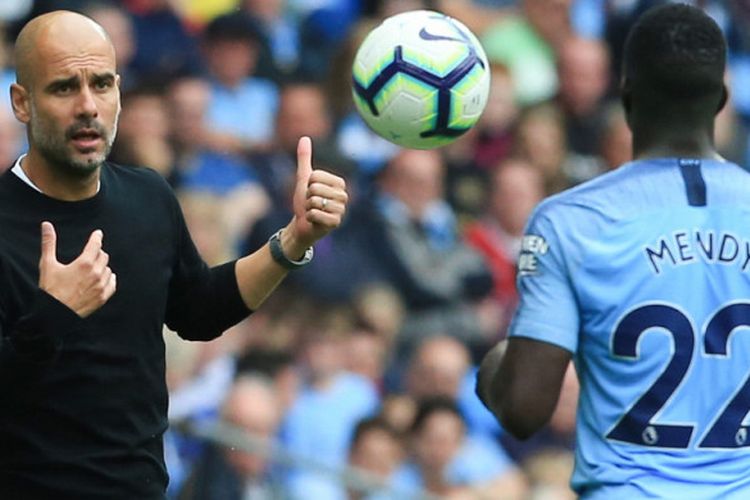 Manajer Manchester City, Pep Guardiola (kiri), saat berbincang dengan bek Benjamin Mendy dalam pertandingan Liga Inggris kontra Huddersfield di Stadion Etihad, 19 Agustus 2018. 