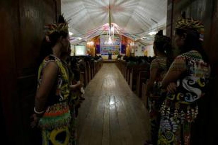 Gadis Dayak menerima tamu yang datang merayakan Natal bersama Bupati Malinau di gereja Desa Sungai Barang, Kayan Selatan, 3 Desember 2014. Sungai Barang merupakan salah satu desa yang terletak di perbatasan Indonesia - Malaysia.