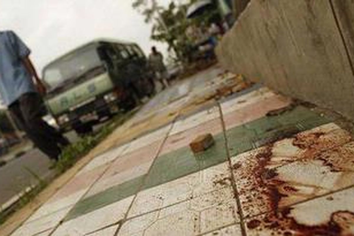 Warga melintas di samping darah yang mulai mengering bekas seseorang yang ditembak dan diduga teroris dalam penyergapan oleh Densus 88 di Jalan Mayjen Sutoyo, Jakarta Timur, Rabu (12/5/2010). Pada saat yang sama Densus juga menembak mati dua orang teroris di Cikampek Timur, Kabupaten Karawang.