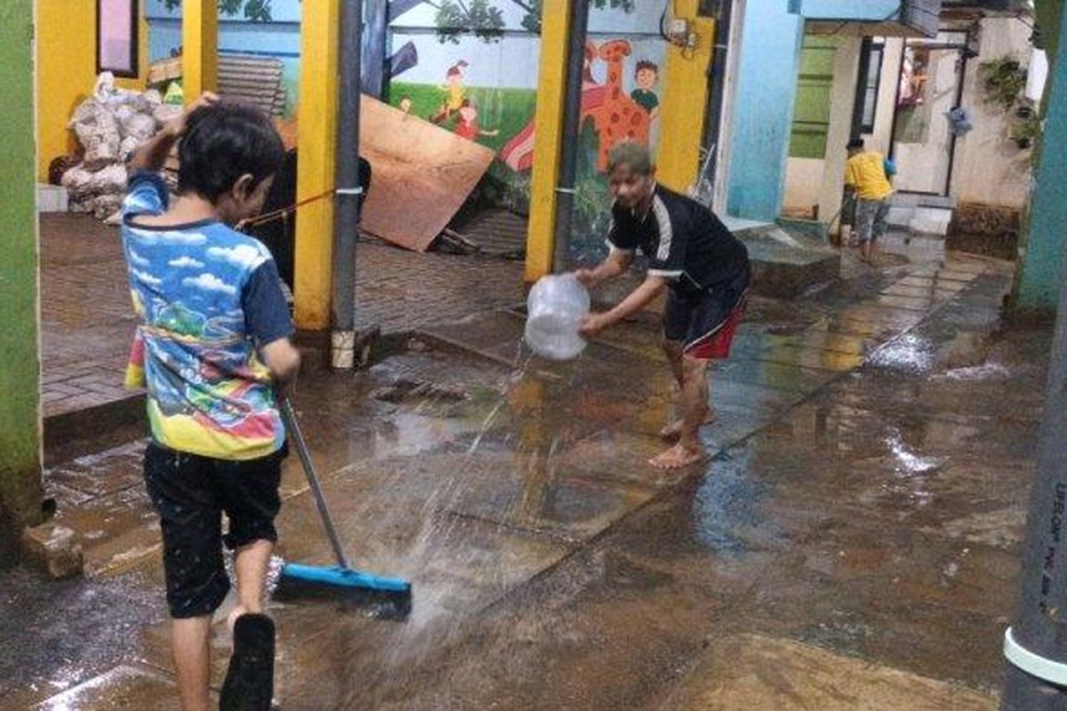 Warga Kebon Pala saat membersihkan timbunan lumpur bercampur sampah imbas banjir luapan Kali Ciliwung, Jatinegara, Jakarta Timur, Jumat (24/2/2023). 