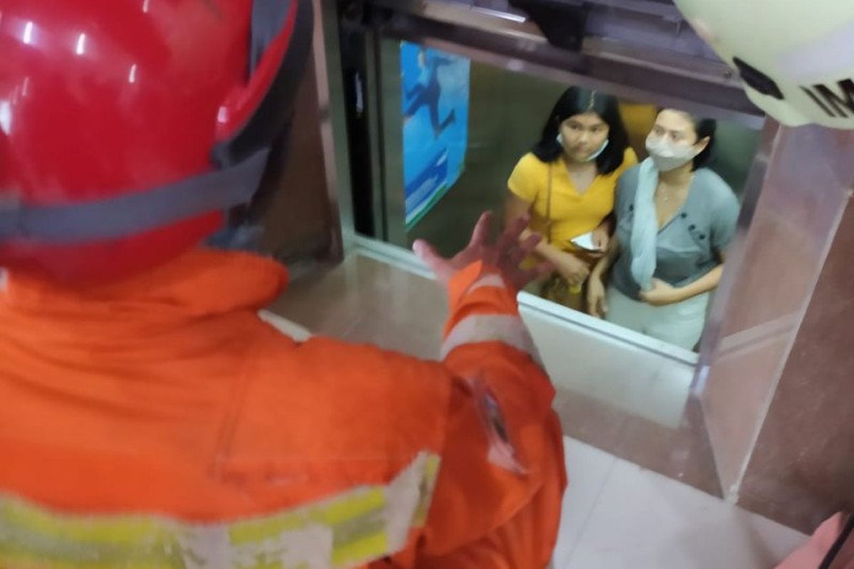 Petugas penyelamatan dari Damkar Jakarta Selatan mengevakuasi ibu dan dua anak yang terjebak di dalam lift gedung Kimia Farma, Grogol Selatan, Jakarta Selatan, Sabtu (31/10/2020).
