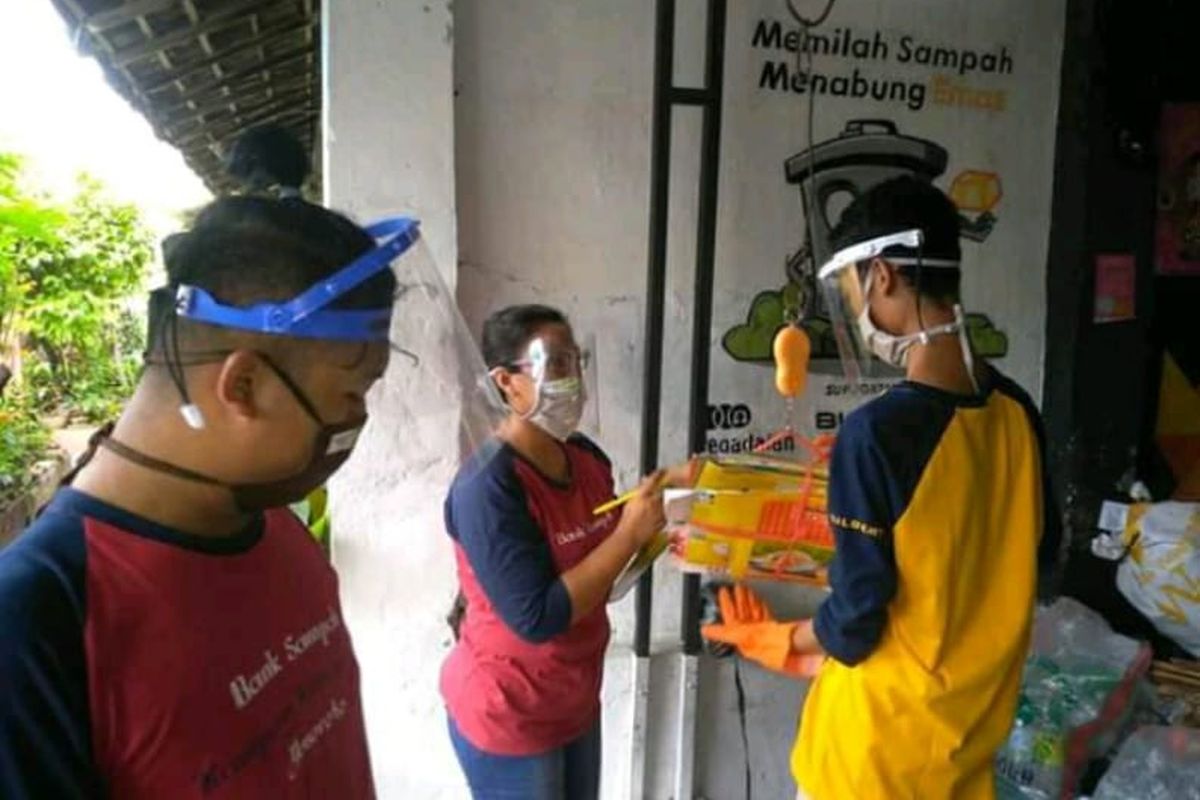 Warga antre menimbang sampah yang sudah dipilah di Bank Sampah di Kampung Kitiran RT 002/ RW 008, Yosoroto, Kelurahan Purwosari, Kecamatan Laweyan, Kota Solo, Jawa Tengah, Sabtu (12/12/2020). Di tengah pandemi Covid-19, warga mengumpulkan sampah dengan menerapkan protokol kesehatan ketat.