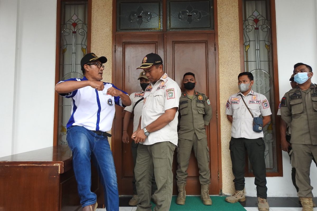 Petugas Satpol PP mencoba menenangkan Agus Sholi yang terlibat aksi kericuhan dengan petugas, Rabu (26/10/2022)