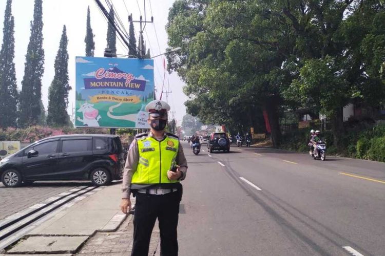 Polisi sedang mengurangi kepadatan kendaraan di Jalan Raya Puncak Bogor, Jawa Barat, Minggu (31/7/2022).