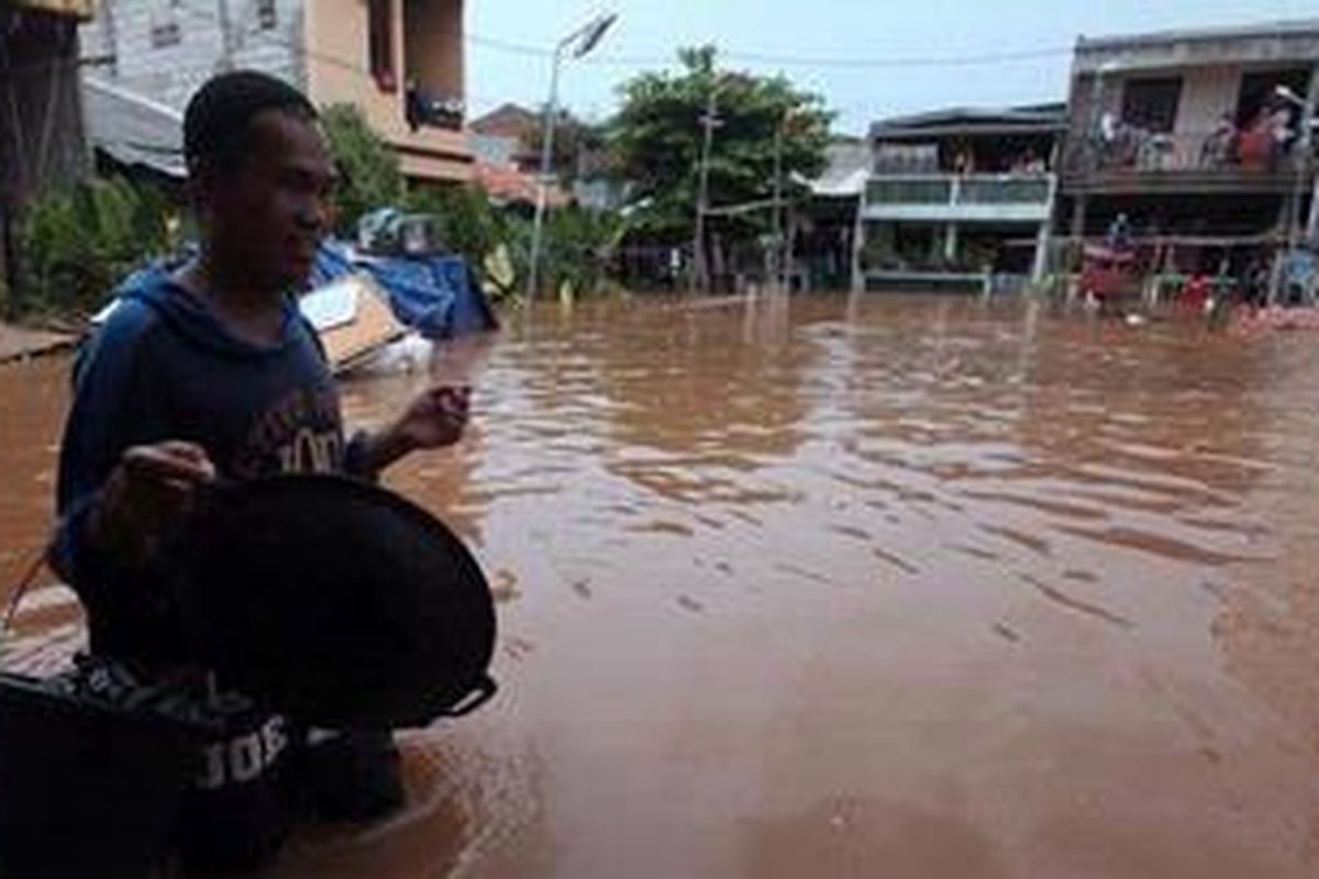 Warga melintas saat banjir menggenangi rumah-rumah di  Kawasan Kedoya Selatan, Jakarta Barat,  Minggu (25/11/2012). Walaupun sempat surut, namun banjir di sejumlah titik di Jakarta kembali naik seiring meluapnya sungai-sungai di Jakarta. 