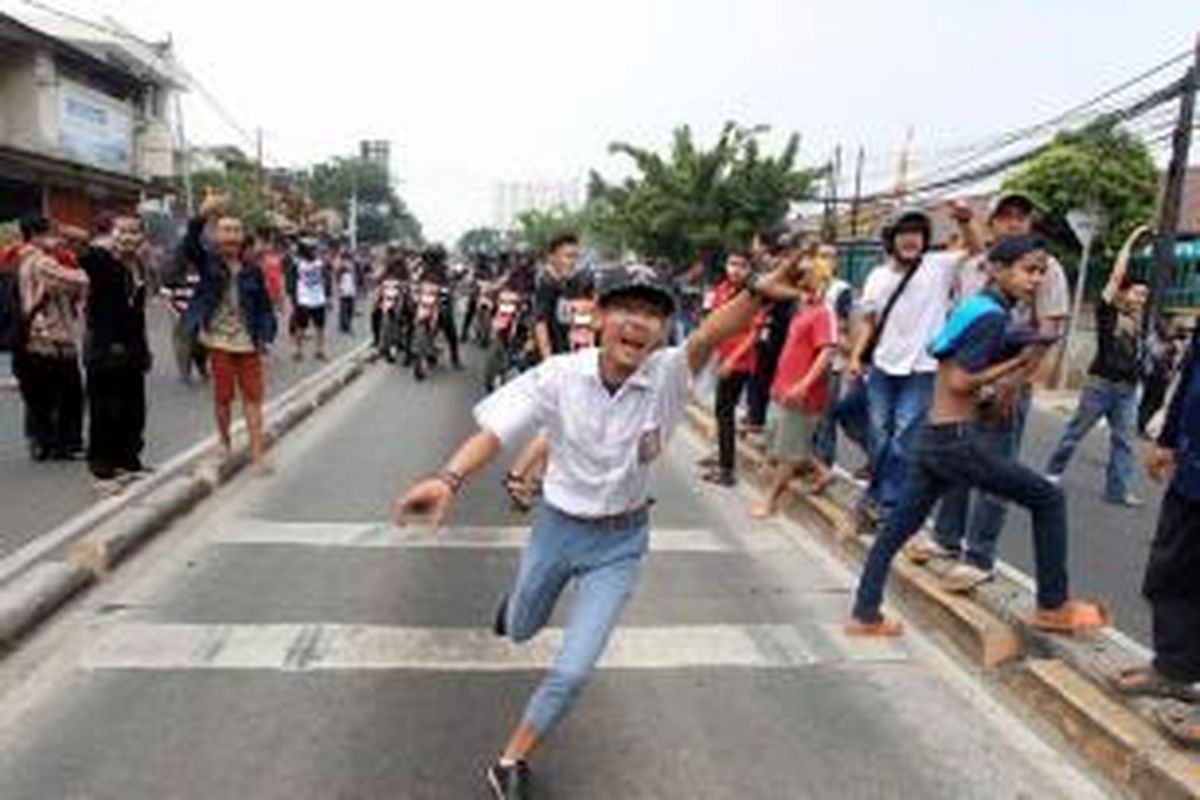 Seorang pelajar terlihat dalam bentrokan warga Kampung Pulo, Jakarta Timur, Kamis (20/8/2015). Bentrokan terjadi karena warga menolak digusur dan dipindahkan untuk normalisasi Kali Ciliwung.