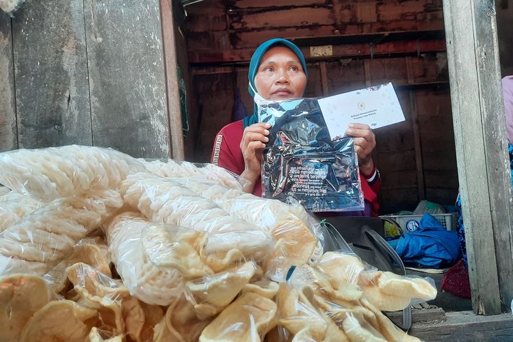 Pedagang Kerupuk, Sutatik mendapatkan uang tunai dan kaos dari Presiden Jokowi saat berada di Pasar Menden, Kecamatan Kradenan, Kabupaten Blora, Jawa Tengah, Jumat (10/3/2023)