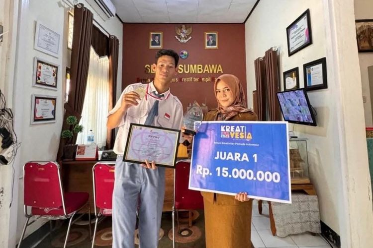 Aan bersama kepala sekolah SLBN 1 Sumbawa berpose dengan piala juara kriya nasional.