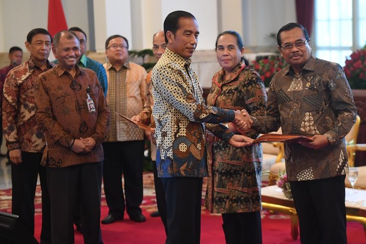 Presiden Joko Widodo (tengah) menyerahkan dokumen strategi nasional (stranas) pencegahan korupsi kepada Jaksa Agung HM Prasetyo (kanan) di Istana Negara, Jakarta, Rabu (13/3/2019). Dokumen yang disusun oleh Tim Nasional Pencegahan Korupsi itu berisi panduan pencegahan tindak pidana korupsi yang berfokus kepada perizinan dan tata niaga, keuangan negara serta penegakan hukum dan reformasi birokrasi. ANTARA FOTO/Akbar Nugroho Gumay/pd.