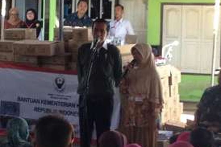 Presiden Joko Widodo membagikan biskuit saat mengunjungi  Tempat Pelelangan Ikan Landangan,  Kecamatan Kapongan Situbondo Rabu (14/9/2016)