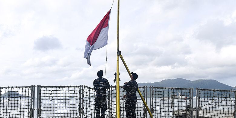 Foto dirilis Selasa (9/6/2020), memperlihatkan dua prajurit TNI AL menaikkan bendera Merah Putih di geladak KRI Usman Harun-539. Demi menjaga kedaulatan RI, TNI menerjunkan delapan KRI yang silih berganti mengamankan Perairan Natuna dari ancaman kapal asing yang ingin mengeruk kekayaan sumber daya perikanan di perbatasan Zona Ekonomi Eksklusif (ZEE) Indonesia tersebut.