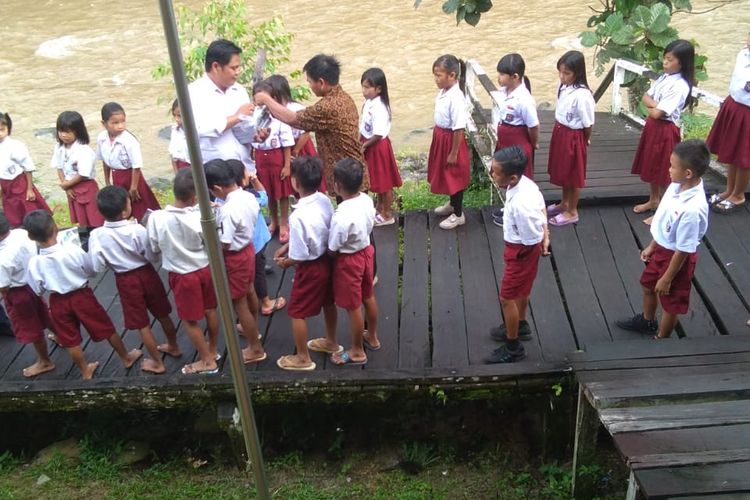 Kornalius (baju putih) saat berada di tengah tengah murid SDN Panas kecamatan Lumbis Pansiangan, sekolah ini berjarak 2 jam dengan desa Salung Malaysia (Konalius)