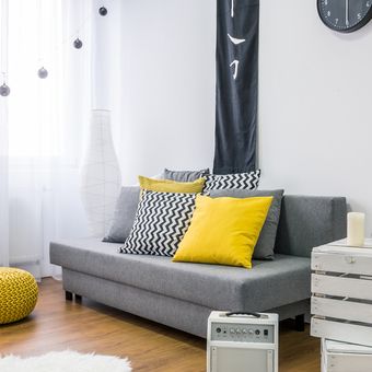 Ilustrasi ruang keluarga dengan nuansa warna kuning dan abu-abu. 