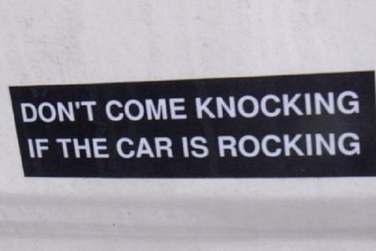Stiker yang bertuliskan Jangan mengetuk pintu, jika Ada melihat mobil bergoyang ditempelkan di dinding ambulans.
