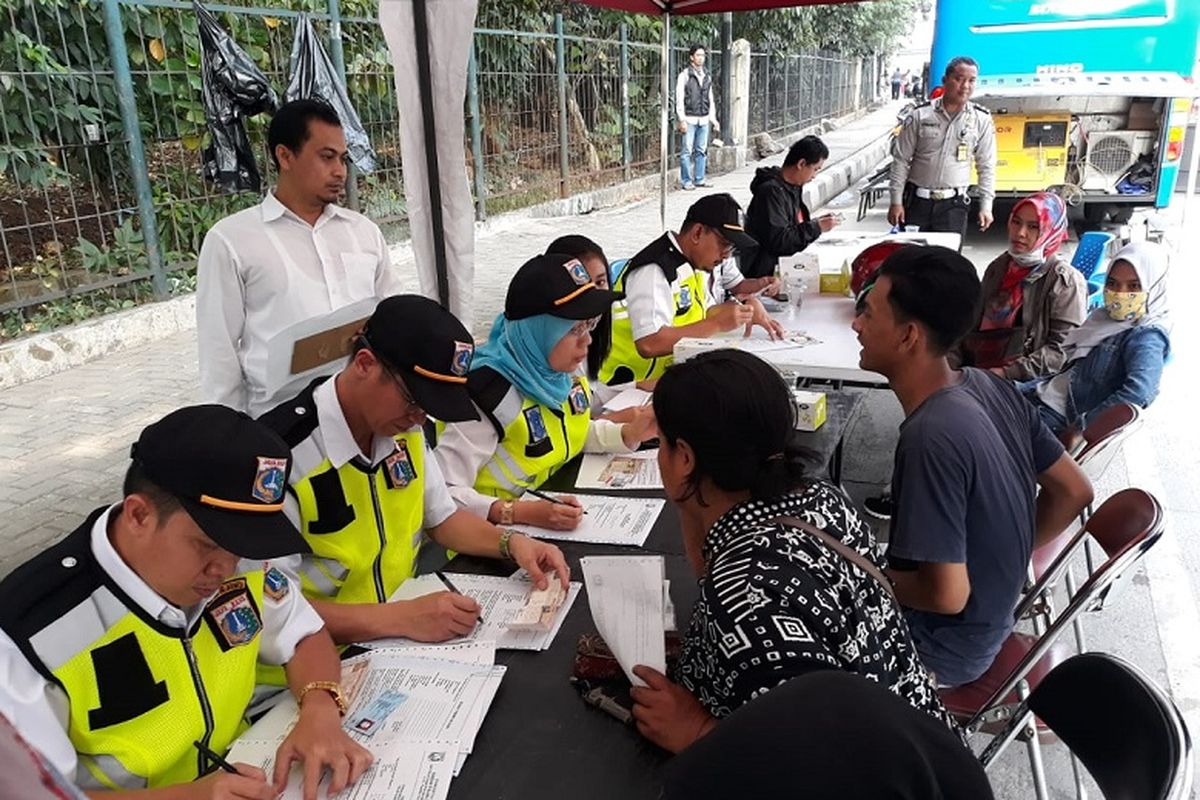 Sejumlah penunggak pajak kendaraan mengurus surat pernyataan membayar pajak setelah terkena razia pajak kendaran di Jalan DI Panjaitan, Jakarta Timur, Rabu (25/7/2018). Mereka  diberikan waktu tiga hari untuk melunasi tunggakan. Bila tidak juga membayar, nomor pelat kendaraan mereka akan diblokir.