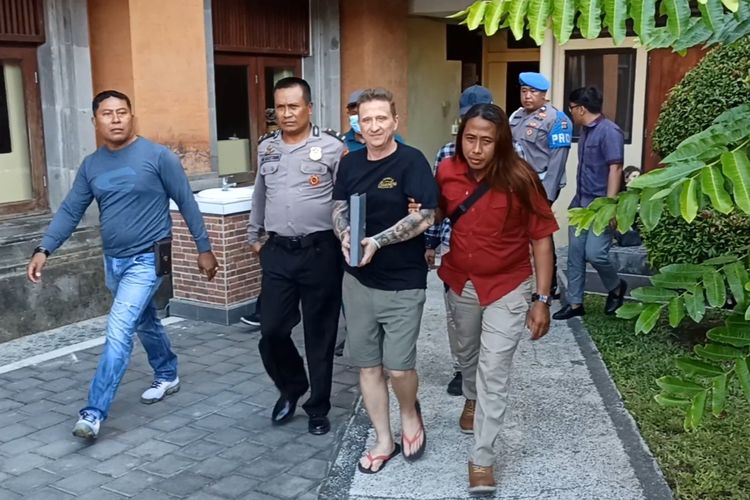 SG (50), saat keluar dari Rutan Polda untuk menjalani proses deportasi melalui Bandara Ngurah Rai, pada Kamis (8/6/2023). SG merupakan warga negara Kanada yang ditangkap usai dinyatakan sebagai buronan Interpol. Kompas.com/ Yohanes Valdi Seriang Ginta