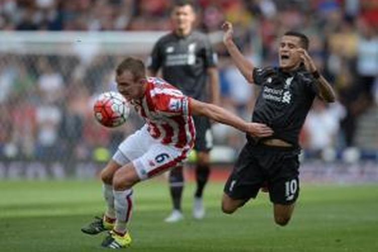 Gelandang Stoke City, Glenn Whelan, berduel dengan gelandang Liverpool, Philippe Coutinho, ketika kedua tim bertemu di Stadion Britannia , Minggu (9/8/2015).