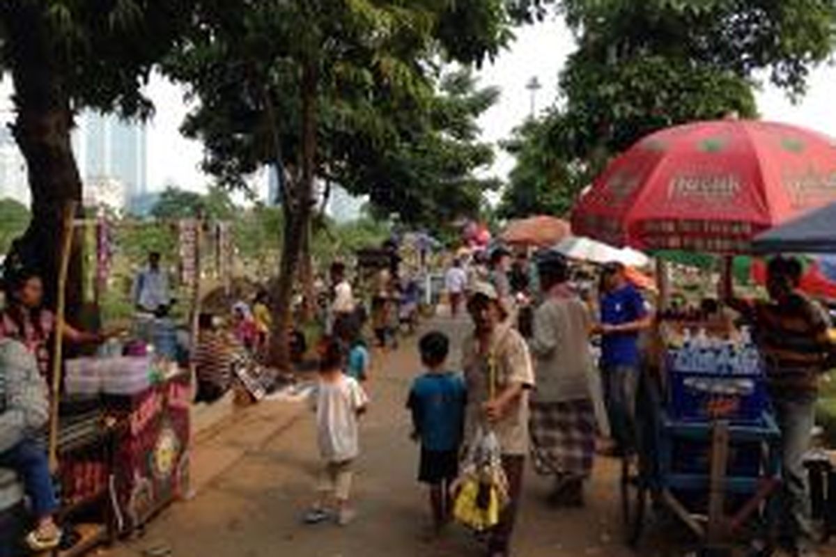 Pedagang dan penyandang masalah kesejahteraan sosial (PMKS) memenuhi jalan di dekat pintu utama Taman Permakaman Umum (TPU) Karet Bivak, Jakarta Pusat, Minggu (14/6/2015). 