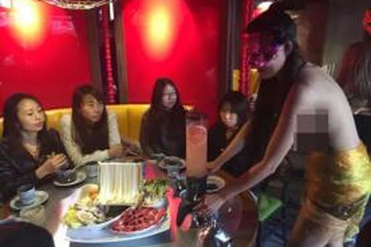 Seorang model topless saat melayani pengunjung restoran di Shenyang, China.