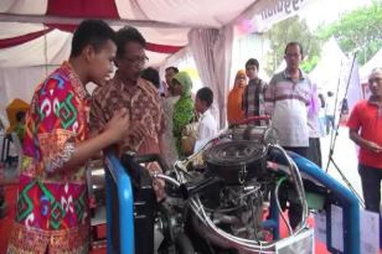 Tri Waluyo, Siswa SMK 2 Takengon Aceh Tengah memberi penjelasan kepada pengunjung tentang mekanisme kerja mesin pengirit bahan bakar hasil temuannya yang menjadi Peringkat I Nasional Karya Teknologi Tepat Guna di Arena Pameran TTG XVII di Banda Aceh.
