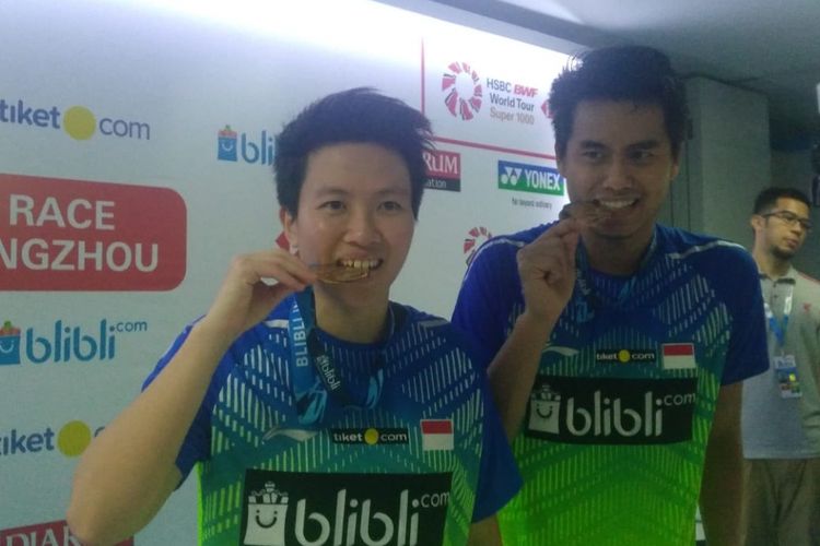 Ganda campuran Indonesia, Tontowi Ahmad dan Liliyana Natsir menggigit medali juara Indonesia Open 2018 di Istora Senayan, Minggu (8/7/2018)