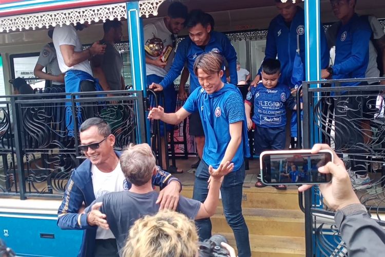 Para punggawa tim Arema FC yang menggunakan Bus Macito (Malang City Tour) setelah diarak oleh Aremania mulai dari exit tol Singosari menuju mess para pemain pada Senin (18/7/2022). 