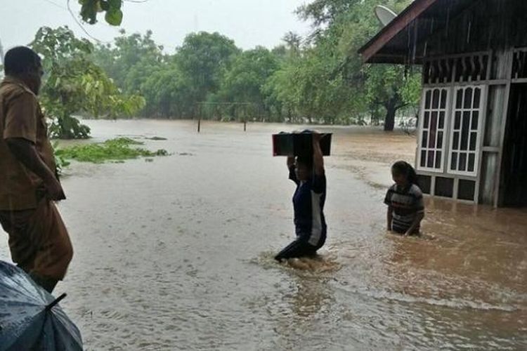 Rumah Milik warga di Kecamatan Kakuluk Mesak, Kabupaten Belu, Nusa Tenggara Timur (NTT) terendam banjir. Camat kakuluk Mesak, Tarsisius Naisali (kiri) turun ke lokasi untuk mengevakuasi warganya.