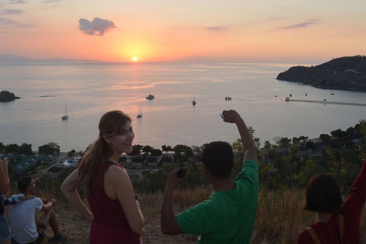 Turis Amerika sedang menikmati matahari terbenam di Bukit Silvia Labuan Bajo, Pulau Flores, Nusa Tenggara Timur, Senin (28/8/2017).