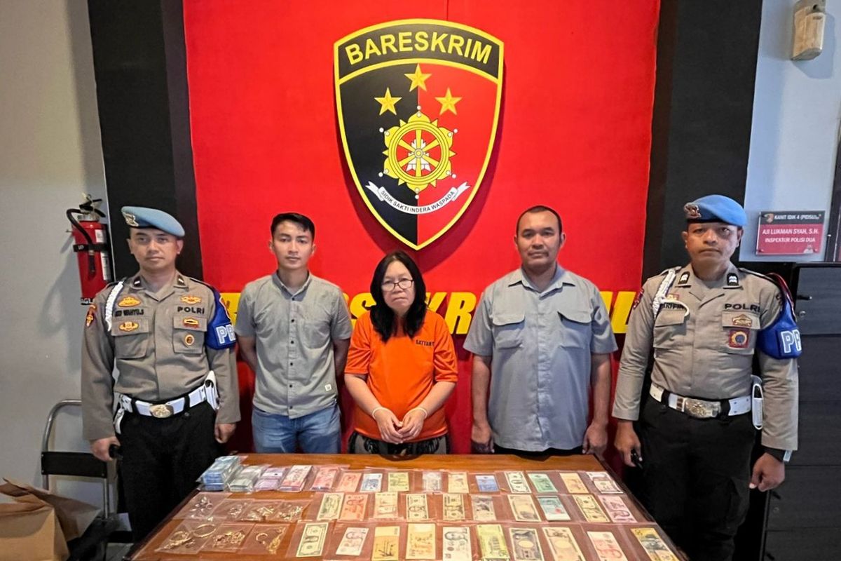 Tersangka Tri Suswati (tengah, memakai baju tahanan berwarna oranye) dengan barang-barang yang dicuri dari brankas korban.