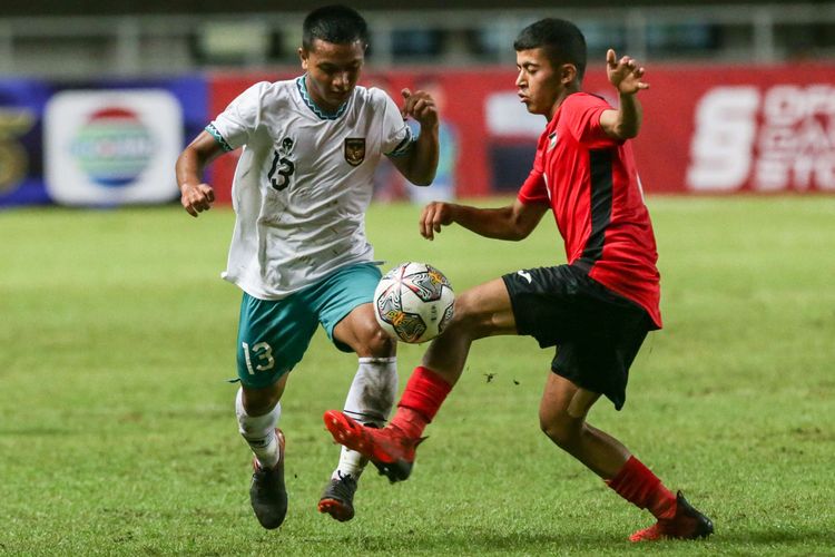 Pemain timnas U17 Indonesia Azzaky Esa Erlangga  berebut bola dengan pemain timnas U17 Palestina Mohanad Nouri pada laga Kualifikasi Piala Asia U17 2023 di Stadion Pakansari, Kabupaten Bogor, Jumat (7/10/2022). Indonesia menang dengan skor 2-0.